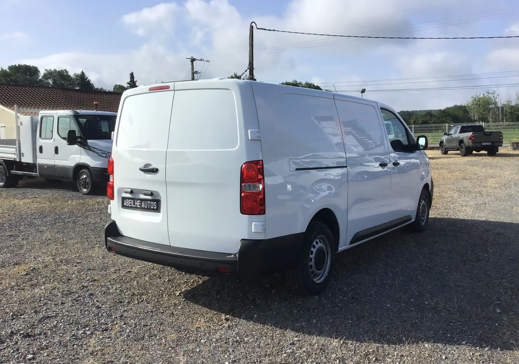 Vue 3/4 arrière droite d'un utilitaire Citroën Jumpy XL blanc, avec portes arrière pleines et pare-chocs noir.