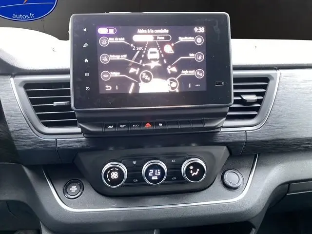 Tableau de bord du Renault Trafic noir 2025 avec écran tactile affichant l'aide à la conduite et commandes climatisation digitales.