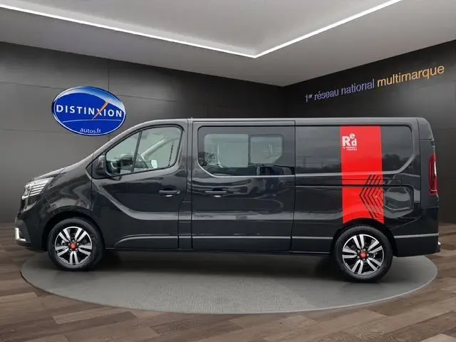 Profil côté gauche du Renault Trafic Cabine Approfondie noir 2025 avec jantes alu noires et bande rouge distinctive arrière.
