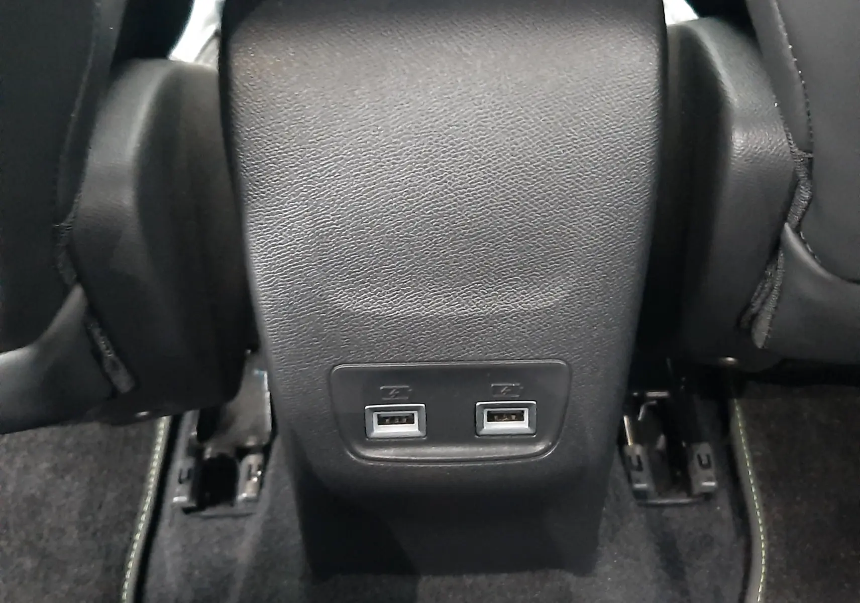 Prise USB double en gros plan sur la console arrière noire du Peugeot 2008 2023 blanc nacré toit noir.