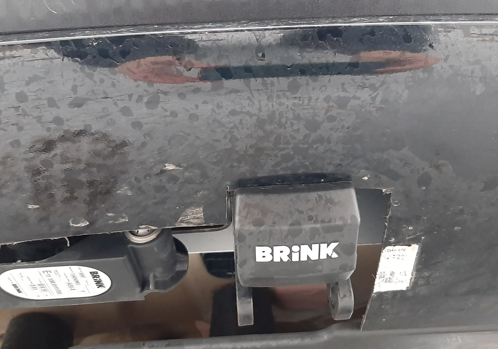 Gros plan sur l'attelage Brink fixé à l'arrière noir brillant du Peugeot 2008 blanc nacré 2023.