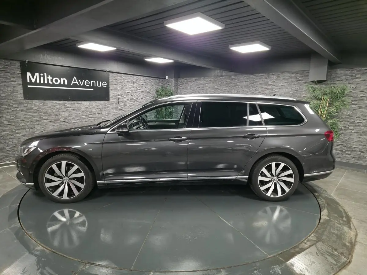 Profil côté gauche d'une Volkswagen Passat SW gris métallisé avec jantes alliage 18 pouces Dartford dans un showroom.