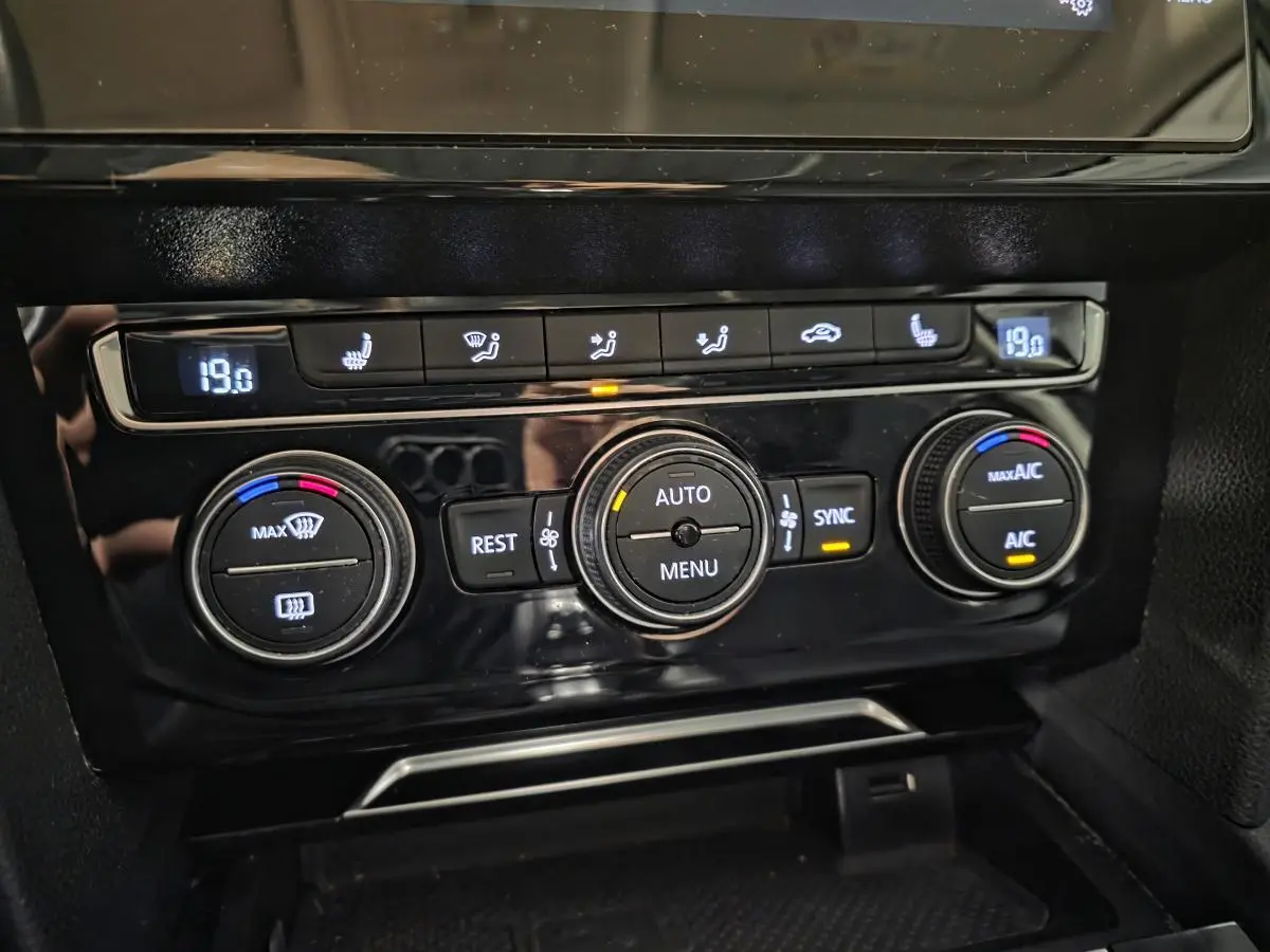 Panneau de commande de la climatisation automatique tri-zone noir brillant dans une Volkswagen Passat SW gris 2019.