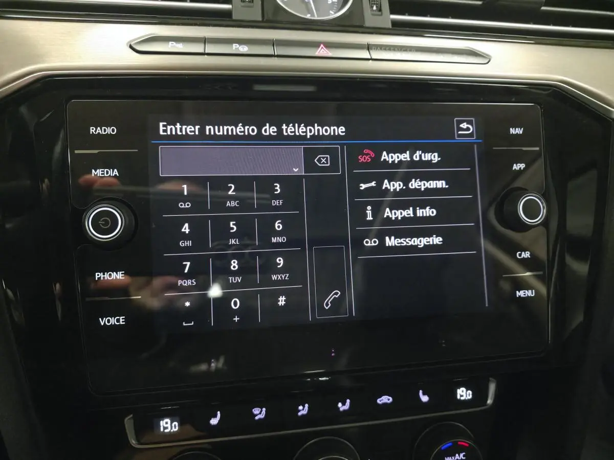 Écran tactile central de la Volkswagen Passat SW 2019 affichant le clavier pour entrer un numéro de téléphone.