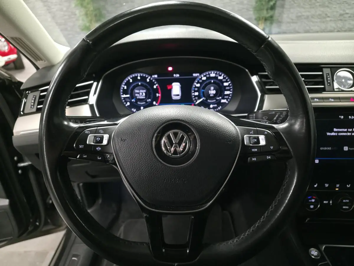 Vue rapprochée du volant en cuir noir multifonction de la Volkswagen Passat SW 2019 avec tableau de bord digital.