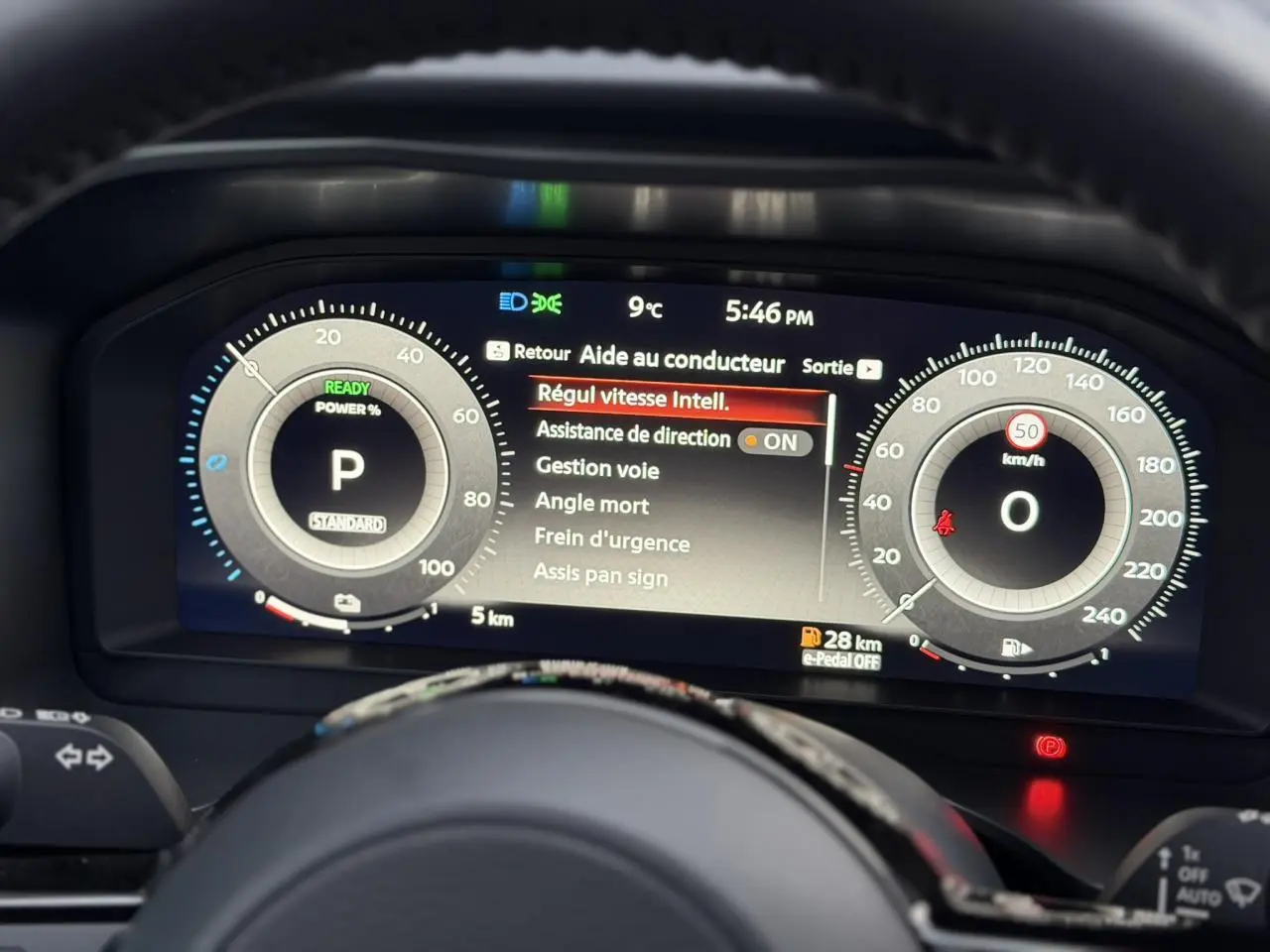 Tableau de bord numérique du Nissan Qashqai gris Squale, vue frontale centrée sur l'affichage des aides à la conduite.