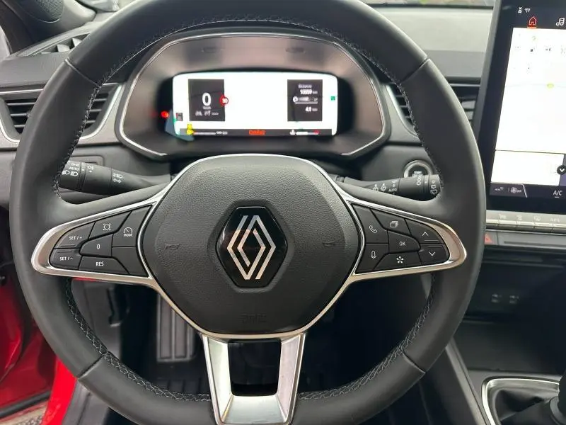 Vue rapprochée du volant noir avec logo Renault, tableau de bord numérique et partie de la console centrale du Captur 2025.
