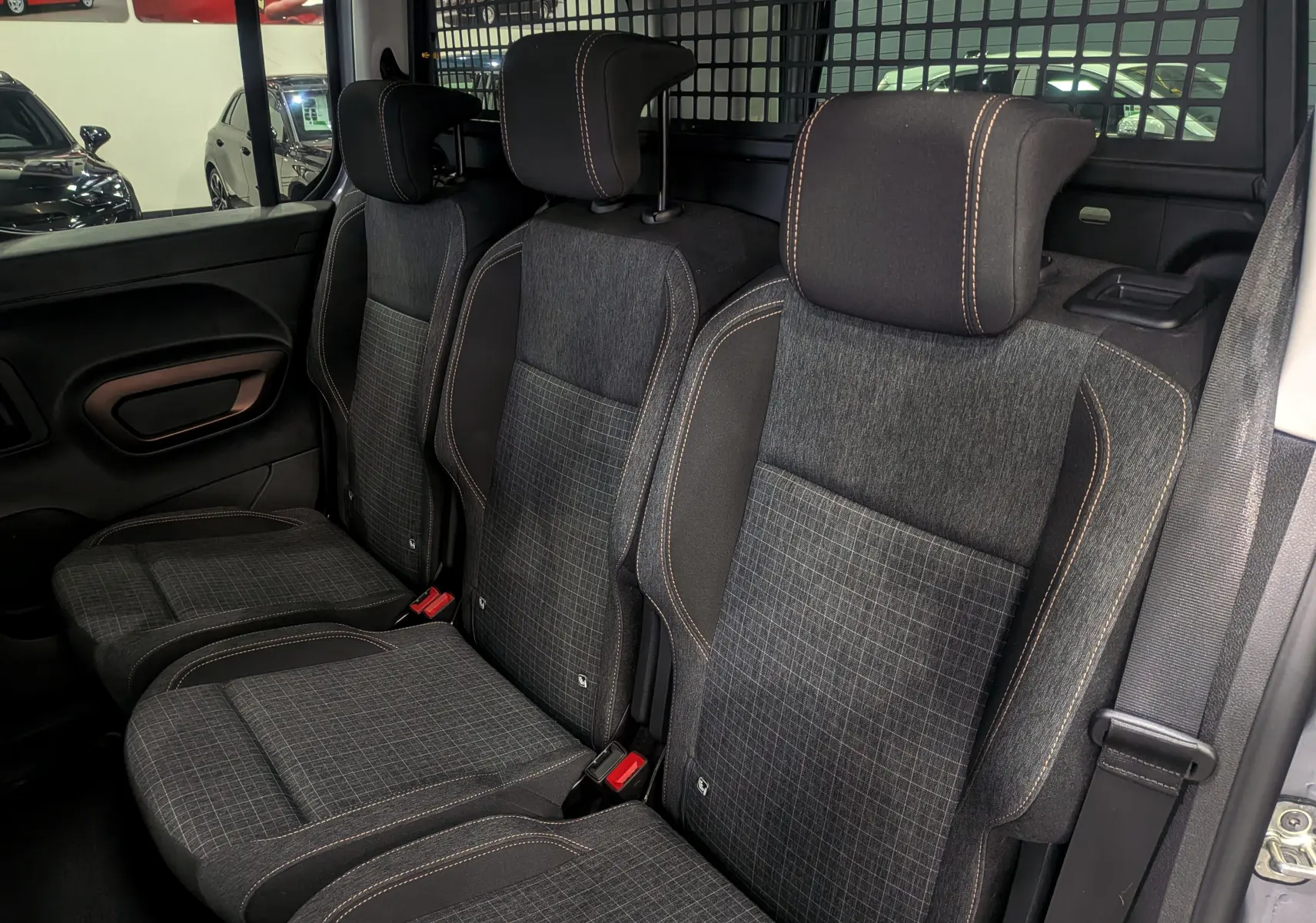 Vue intérieure côté droit des sièges arrière en tissu gris à surpiqûres contrastantes du Peugeot Rifter 2024 Gris Artense.