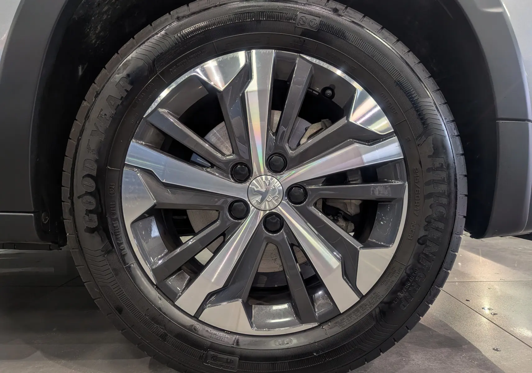 Gros plan sur la roue avant droite du Peugeot Rifter 2024 gris Artense, mettant en valeur le pneu Goodyear.