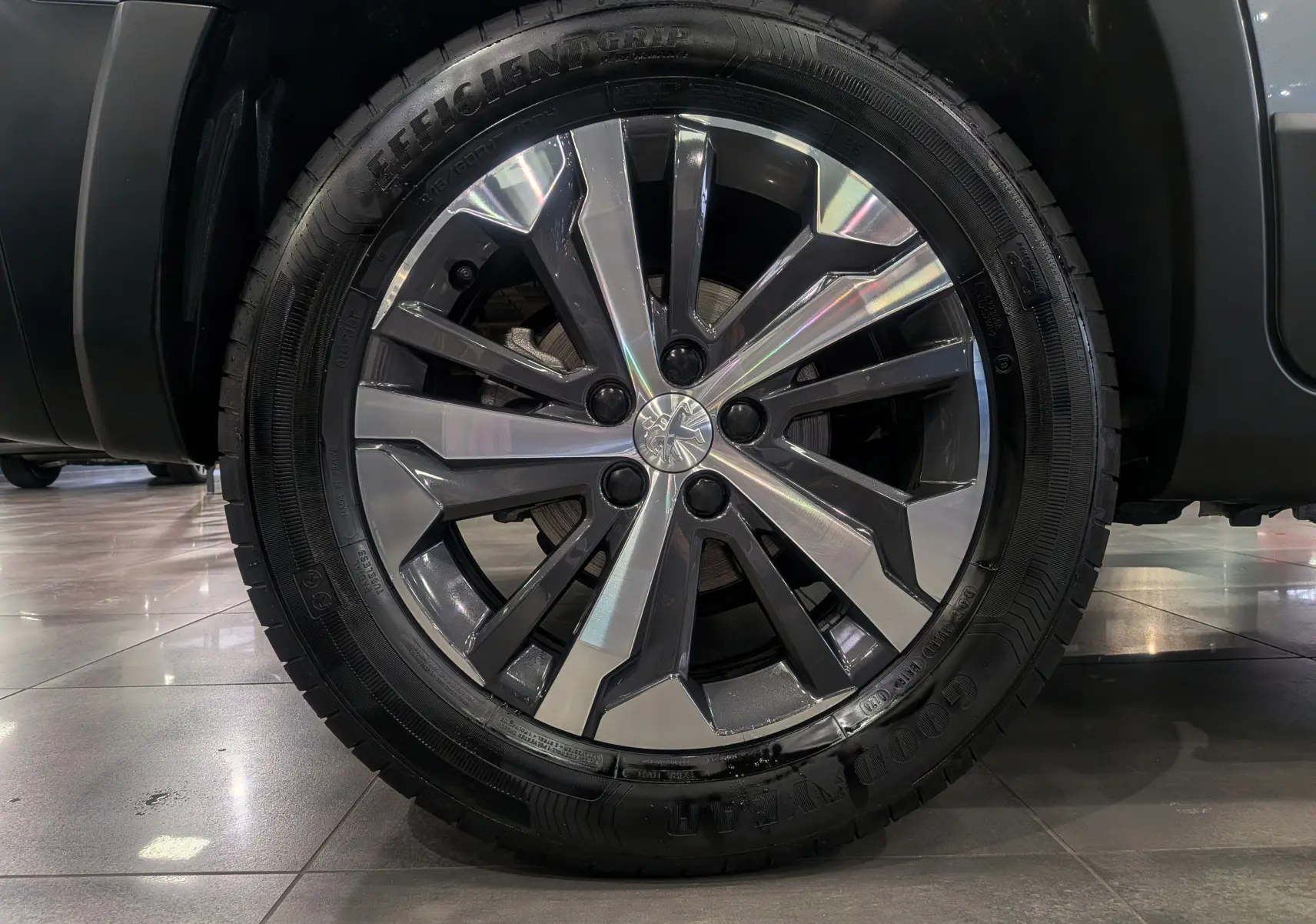 Gros plan sur la jante alliage biton 17 pouces du Peugeot Rifter 2024 gris Artense, mettant en valeur le logo central Peugeot.