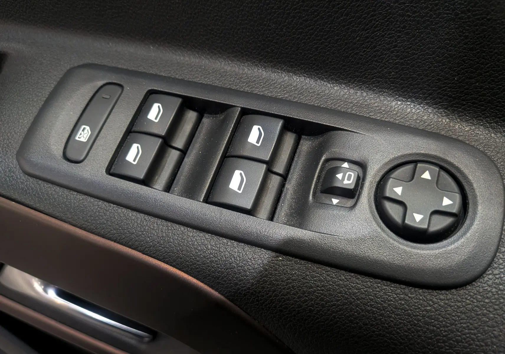 Gros plan sur les commandes de lève-vitres et réglages des rétroviseurs côté conducteur du Peugeot Rifter gris Artense 2024.