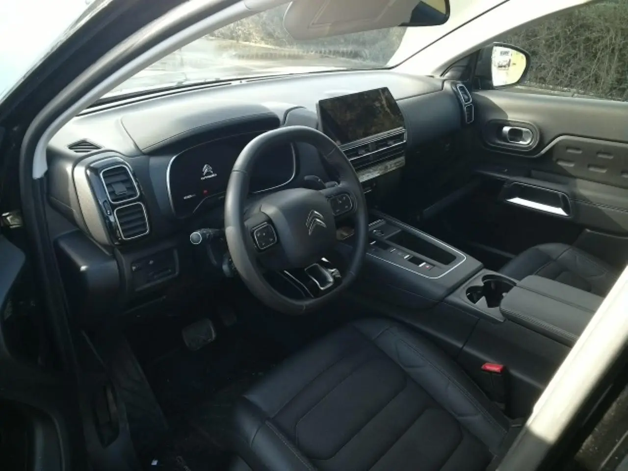 Vue intérieure côté conducteur du Citroën C5 Aircross 2024, avec tableau de bord noir et écran tactile central.