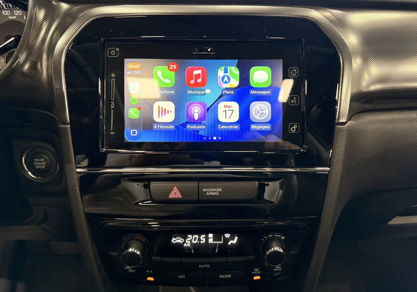 Vue rapprochée de l’écran tactile central et de la console noire brillante du Suzuki Vitara 2023, affichant Apple CarPlay.