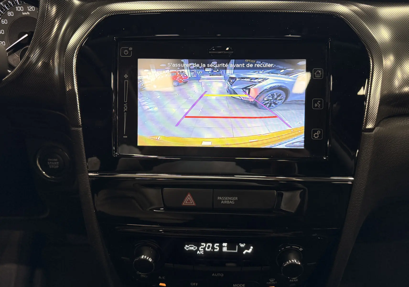 Vue intérieure centrée sur l'écran multimédia affichant la caméra de recul du Suzuki Vitara jaune toit noir 2023.