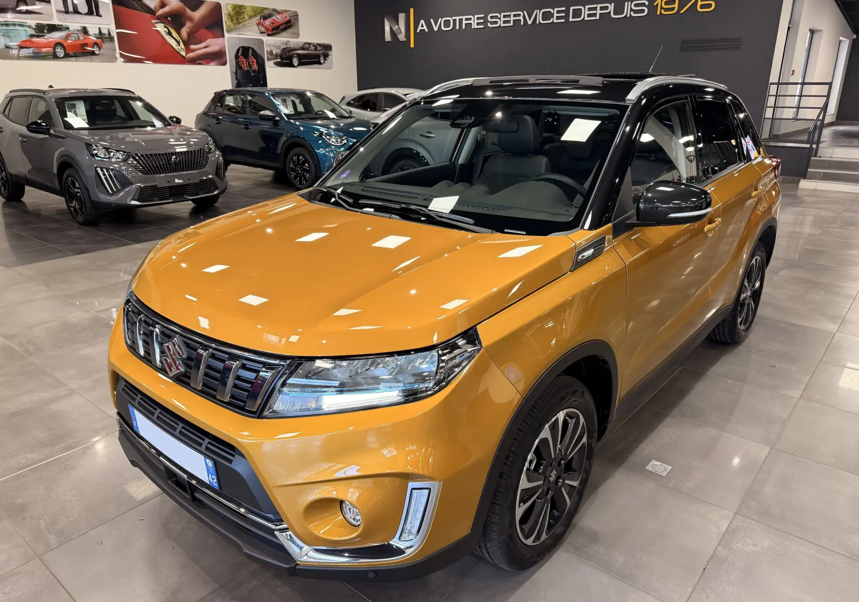 Suzuki Vitara 1.5 Hybrid jaune toit noir en 3/4 avant droit, avec jantes alliage et calandre chromée.