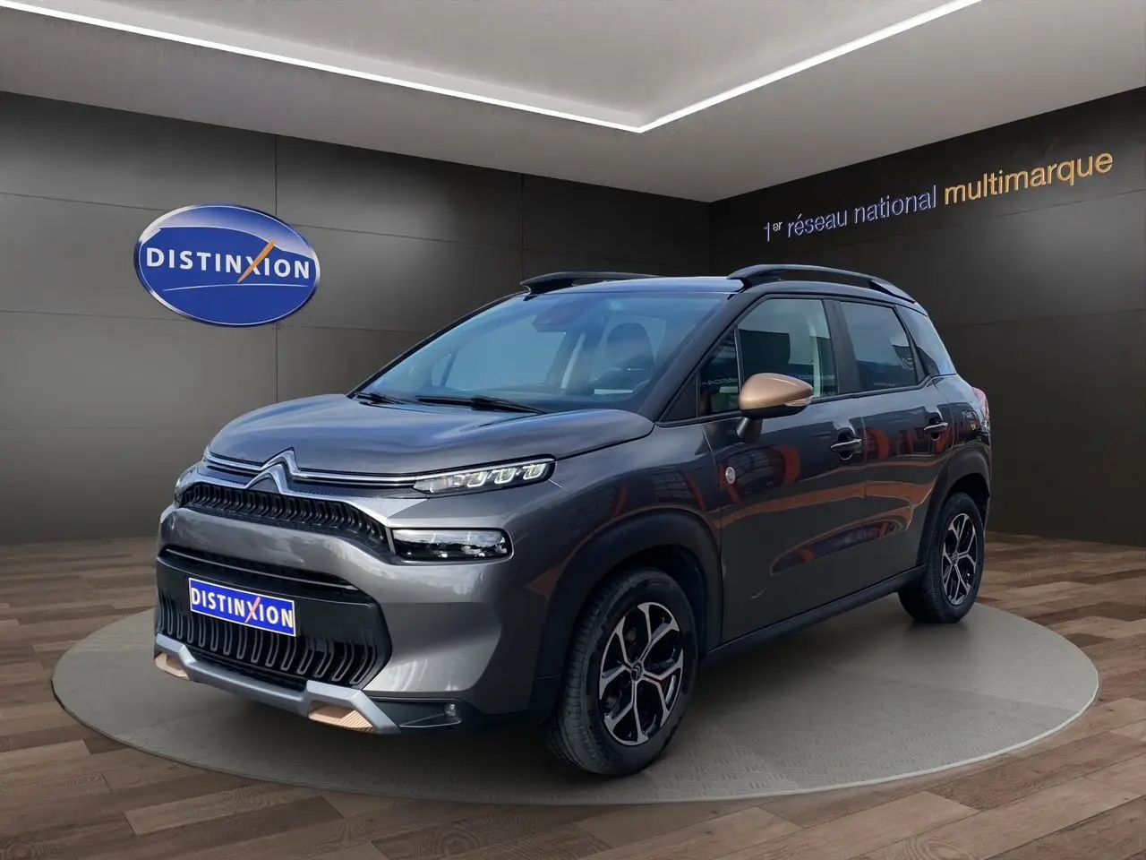 Citroën C3 Aircross gris platinium en 3/4 avant droit, avec détails bronze sur rétroviseurs et jantes noires.