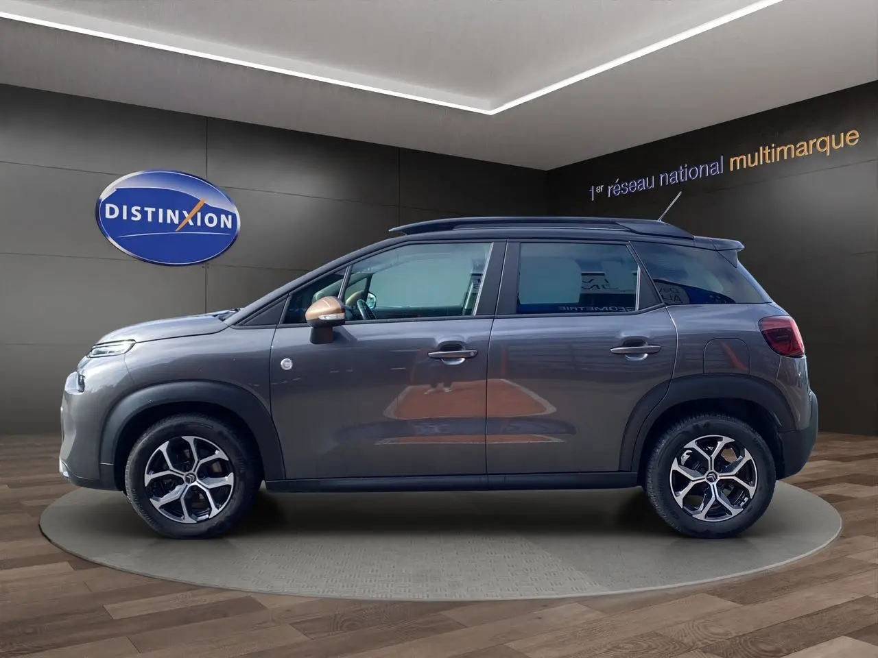Vue de profil côté gauche d'une Citroën C3 Aircross gris platinium avec rétroviseurs couleur cuivre et jantes alliage.