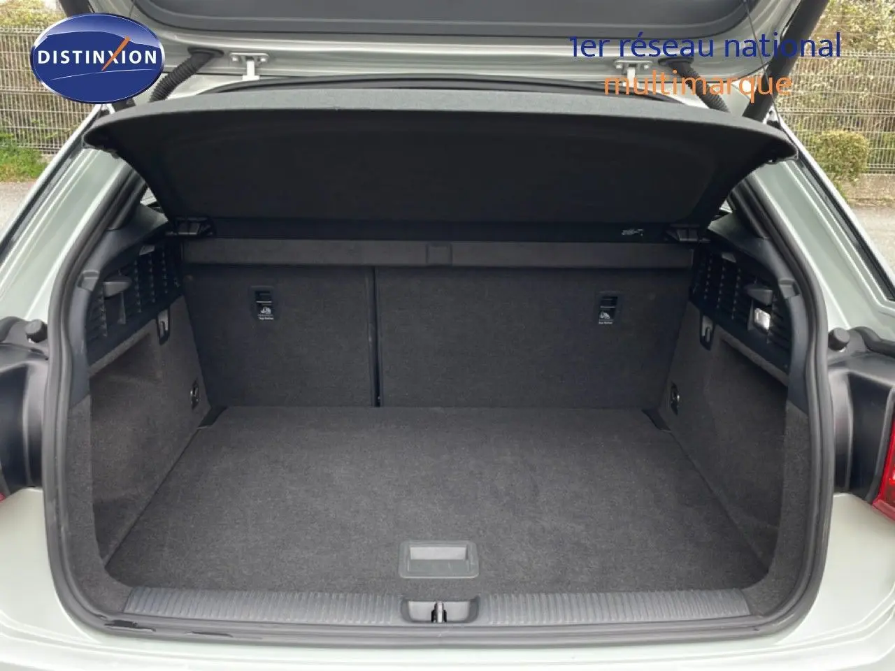 Coffre ouvert vu de l'arrière d'un Audi Q2 35 2.0 TDI S-Line couleur argent rose métal, intérieur noir.