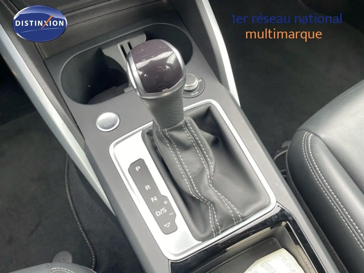 Gros plan sur la console centrale de l'Audi Q2 35 2.0 TDI S-Line 2025, montrant le levier de vitesse automatique en cuir noir.