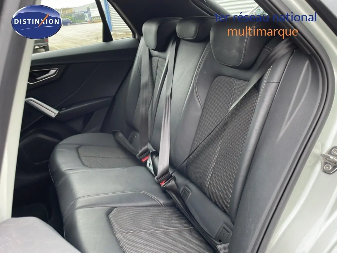 Vue intérieure côté gauche montrant les sièges arrière en cuir noir de l'Audi Q2 35 2.0 TDI S-Line 2025.