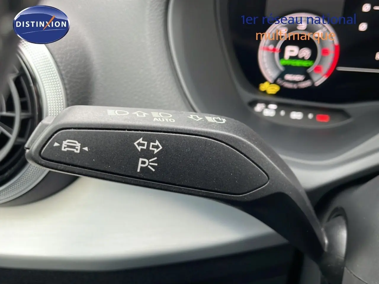 Gros plan sur la manette de clignotant et feux de stationnement dans l'habitacle d'un Audi Q2 2025 argent rose métal.