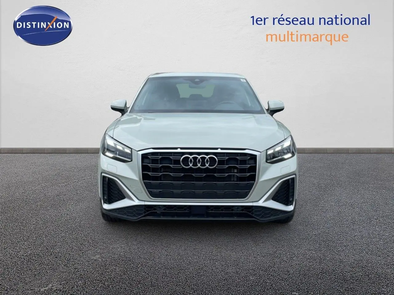 Vue frontale d'un Audi Q2 35 2.0 TDI S-Line en argent rose métal avec calandre noire et phares LED allumés.