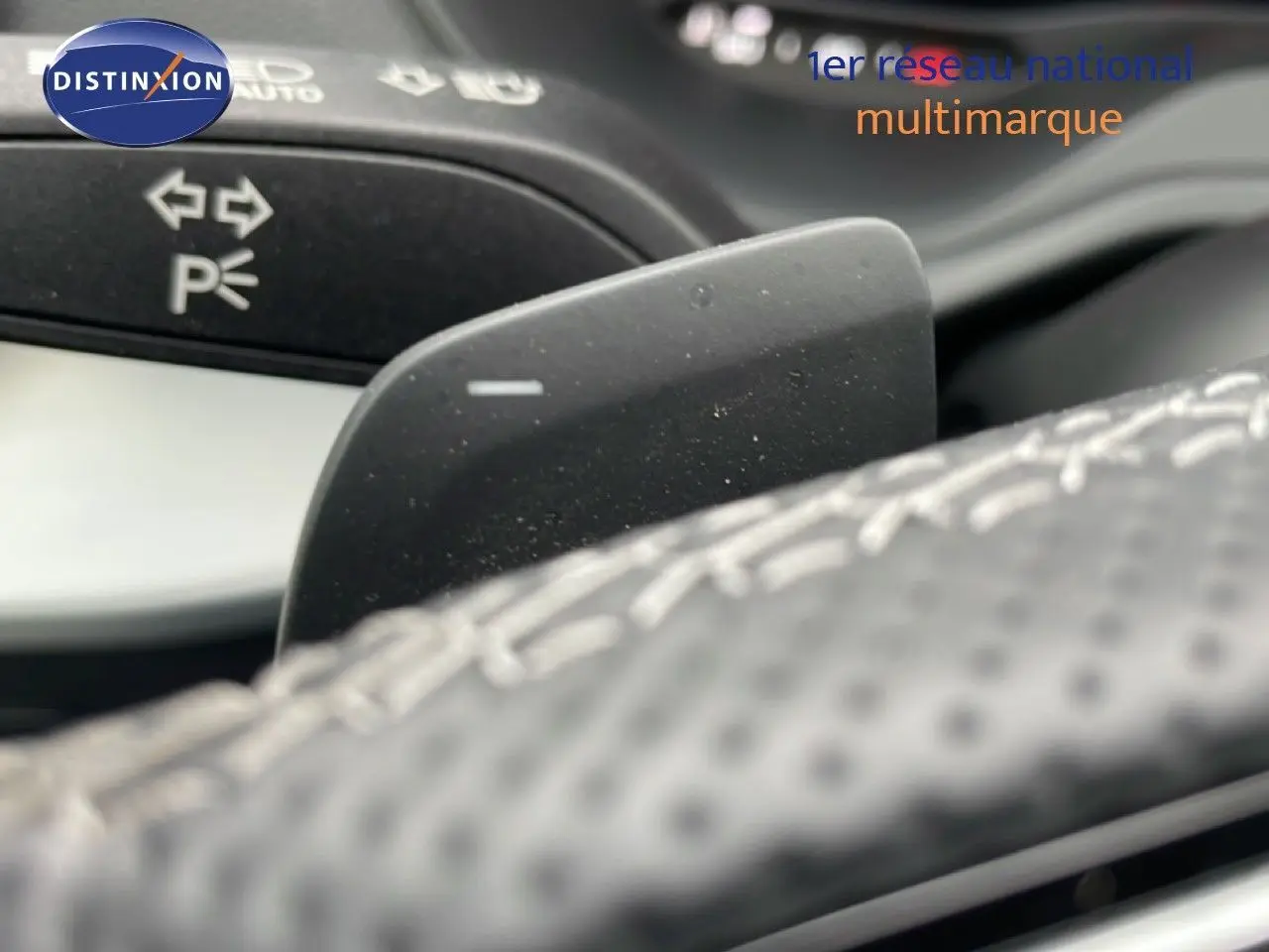 Gros plan sur la palette de changement de vitesse derrière le volant perforé de l'Audi Q2 35 2.0 TDI S-Line.