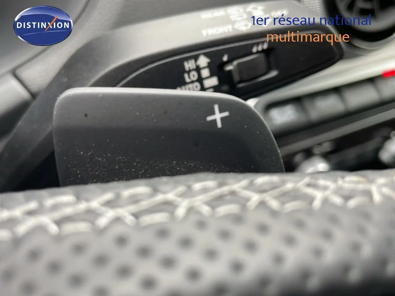 Gros plan sur la palette de changement de vitesse droite dans l'habitacle d'un Audi Q2 2025 argent rose métal.