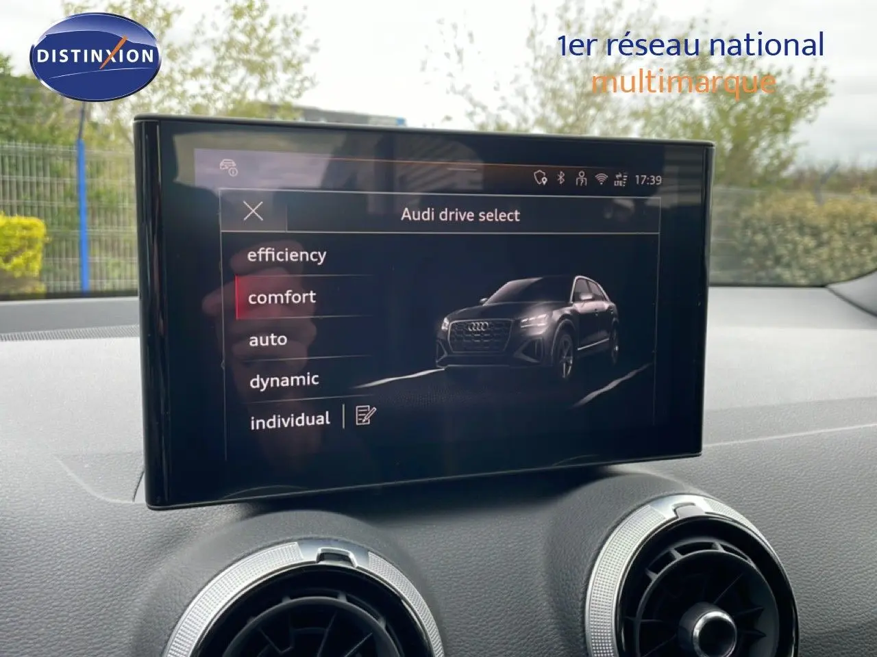 Écran central de l'Audi Q2 35 2.0 TDI S-Line affichant les modes de conduite, intérieur noir visible.