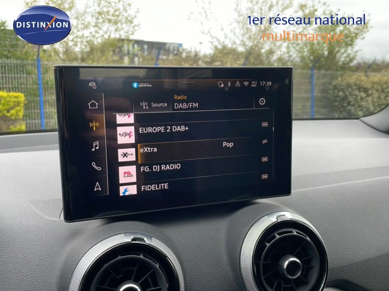 Vue intérieure du tableau de bord de l'Audi Q2 2025 avec écran tactile multimédia et aérateurs ronds argentés.