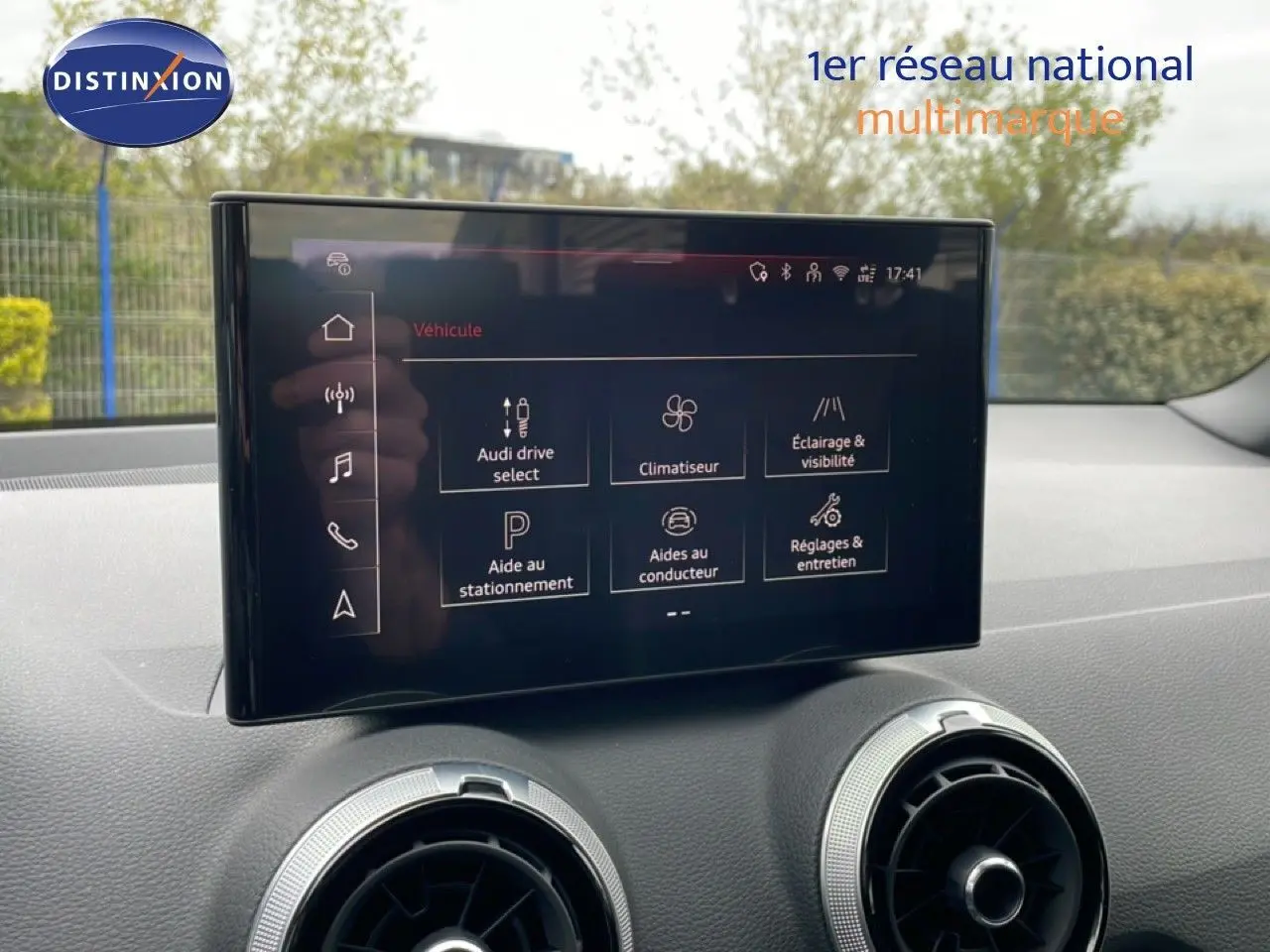 Écran tactile central de l'Audi Q2 2025 affichant les options de conduite et d'assistance, intérieur noir visible.