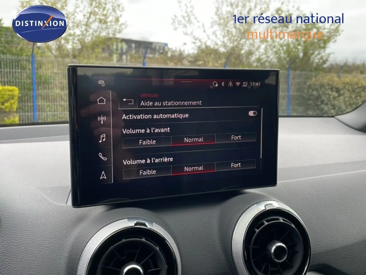 Écran central affichant les réglages d’aide au stationnement dans l’habitacle d’un Audi Q2 argent rose 2025.