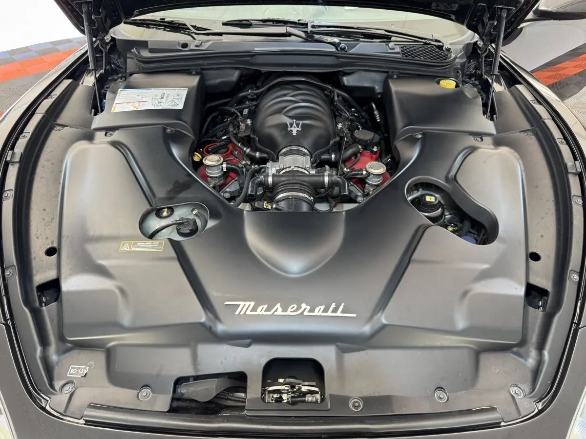 Vue plongeante sur le moteur essence gris foncé de la Maserati Granturismo S 4.7 avec logo Maserati visible.