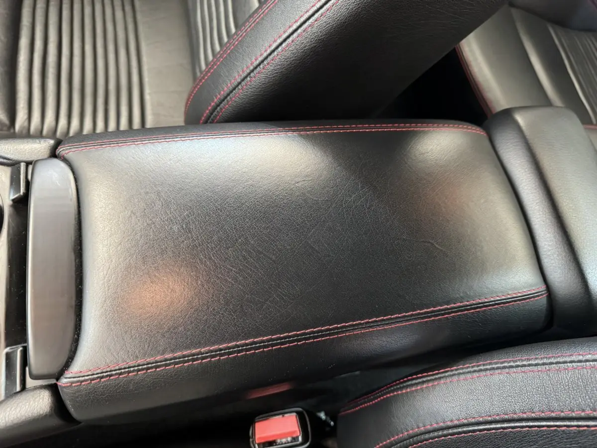 Gros plan sur l'accoudoir central en cuir noir avec surpiqûres rouges dans l'habitacle de la Maserati Granturismo S 4.7.