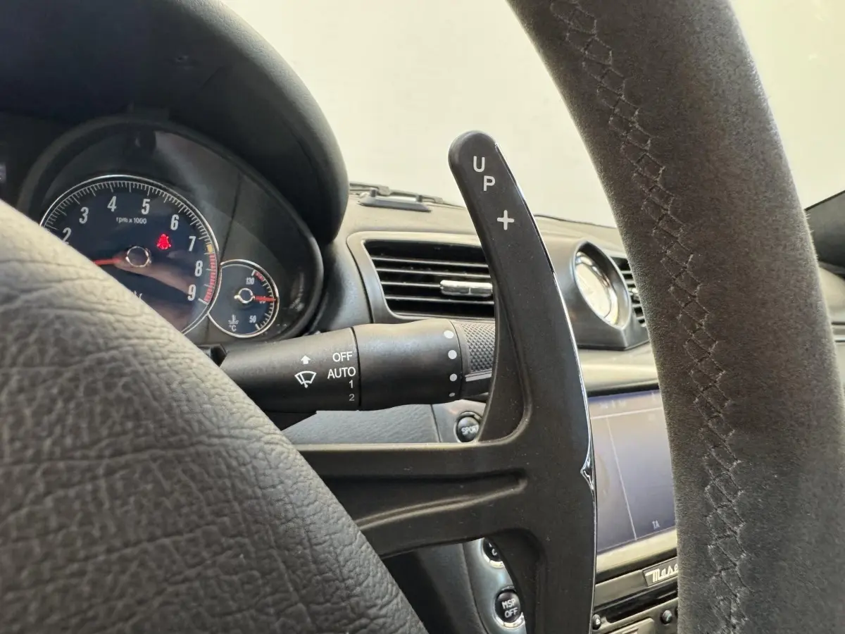 Gros plan sur le volant en daim gris foncé et la palette de changement de vitesse de la Maserati Granturismo S 4.7 de 2010.