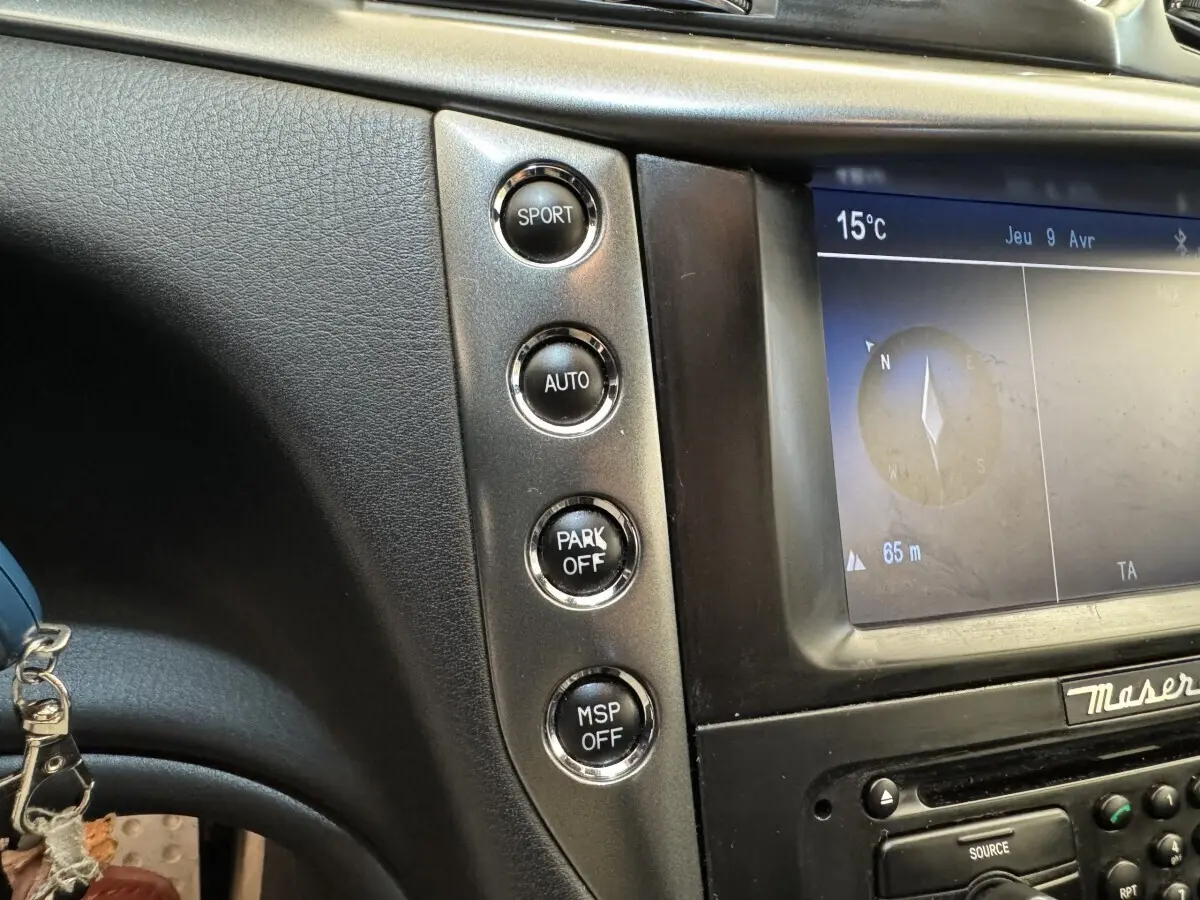 Gros plan sur la console centrale grise de la Maserati Granturismo S 4.7, montrant les boutons Sport, Auto, Park Off et MSP Off.