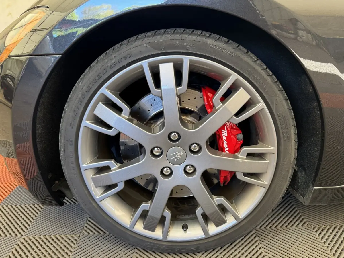 Gros plan sur la roue avant droite grise d'une Maserati Granturismo S 4.7 avec étrier de frein rouge marqué Maserati.