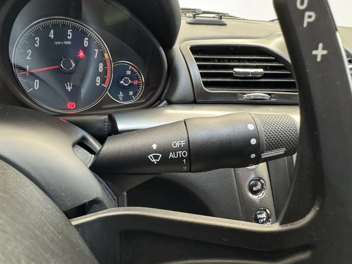 Gros plan sur le tableau de bord gris foncé de la Maserati Granturismo S 4.7, avec compte-tours et commandes au volant.