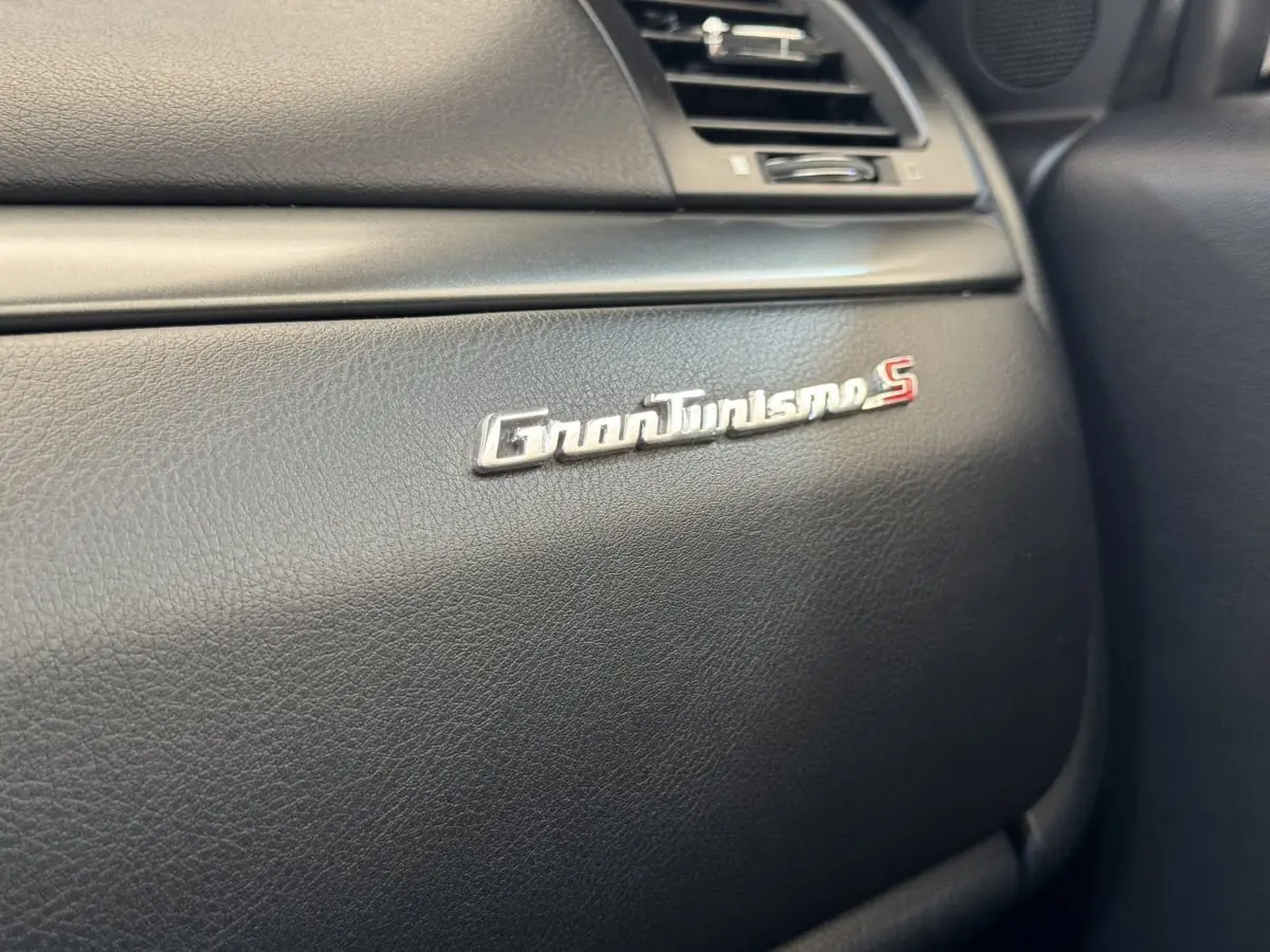 Gros plan sur le logo GranTurismo S argenté sur le tableau de bord noir intérieur d'une Maserati Granturismo S.