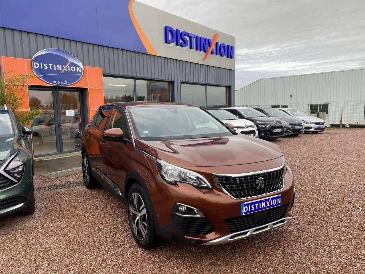 Peugeot 3008 marron foncé vue 3/4 avant, avec jantes alliage 18 pouces, stationnée devant un concessionnaire Distinxion.