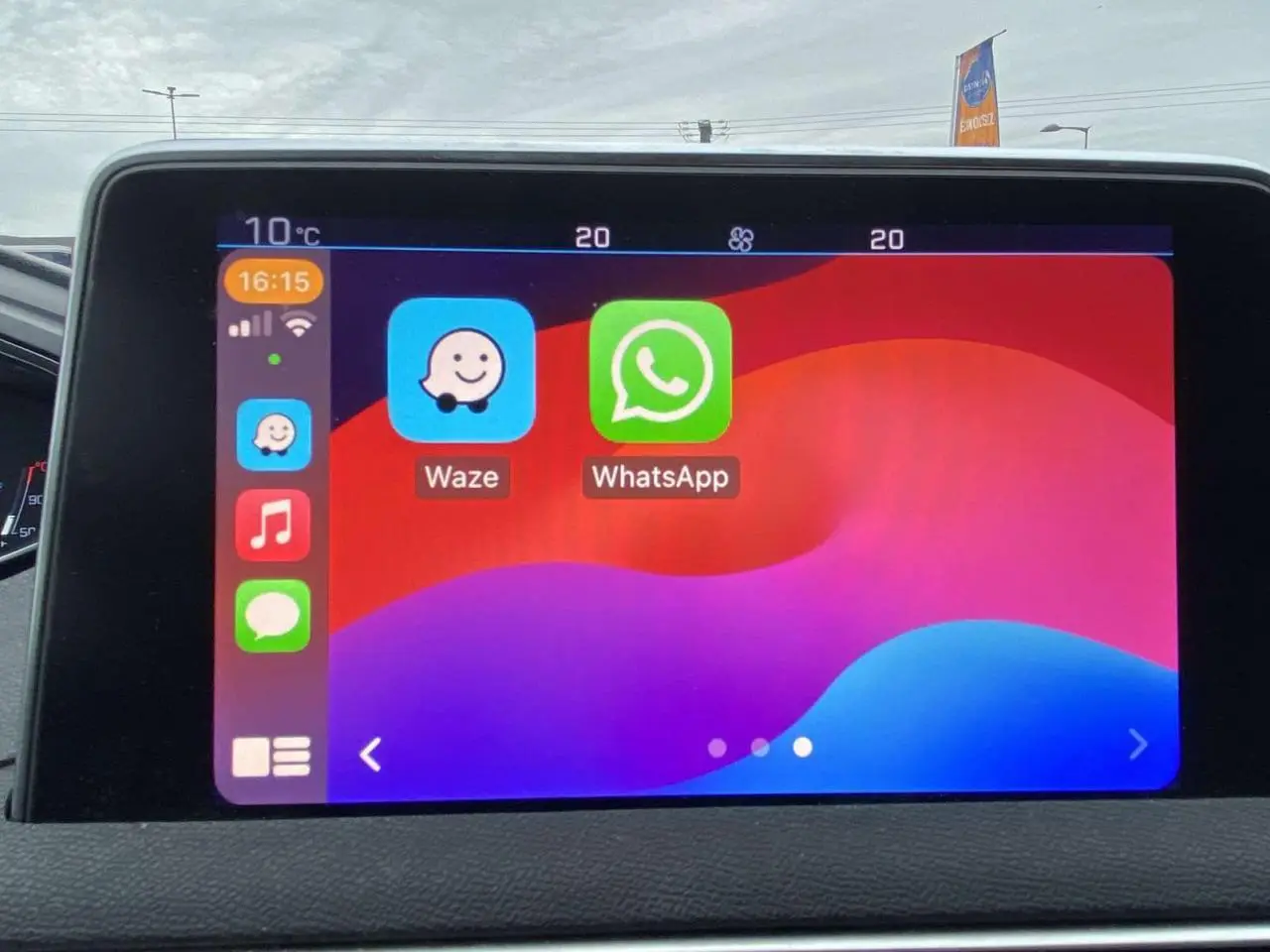 Écran tactile intérieur du Peugeot 3008 affichant les applications Waze et WhatsApp, vue frontale rapprochée.