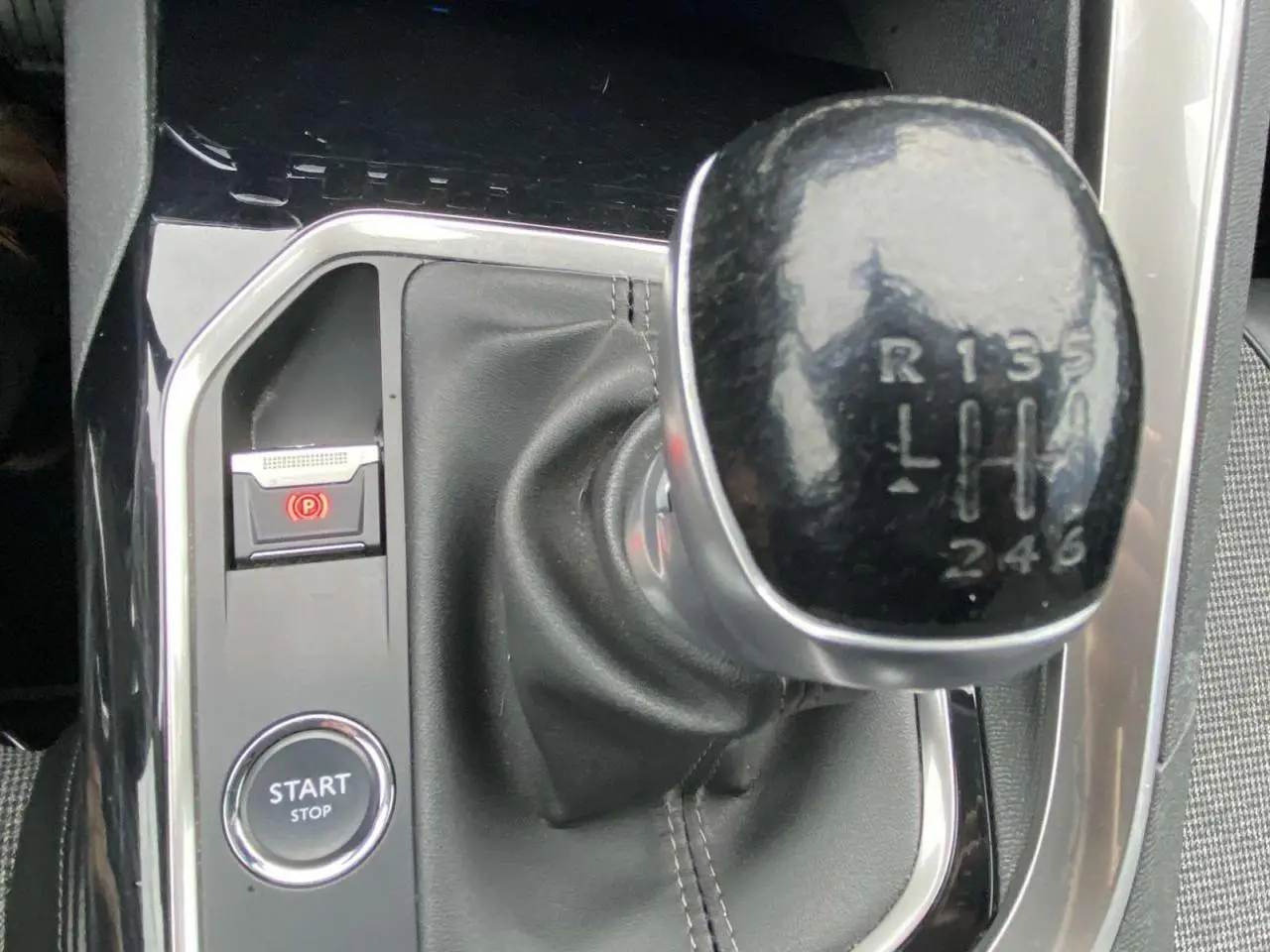 Gros plan sur le levier de vitesses manuelle noir et la console centrale brillante du Peugeot 3008 marron foncé.