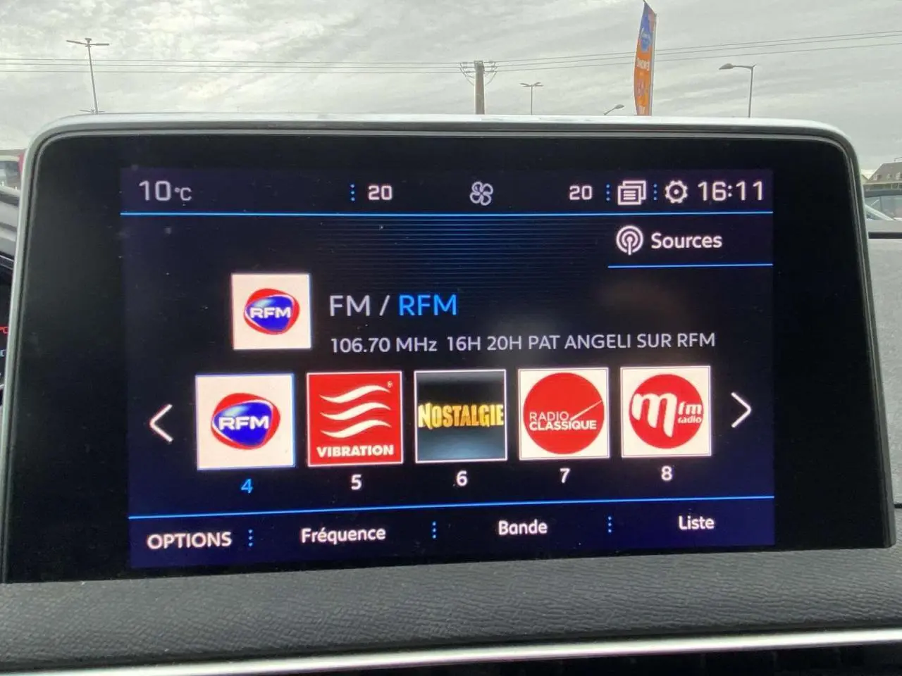 Écran tactile central du Peugeot 3008 2017 montrant les stations radio, avec tableau de bord et pare-brise en arrière-plan.