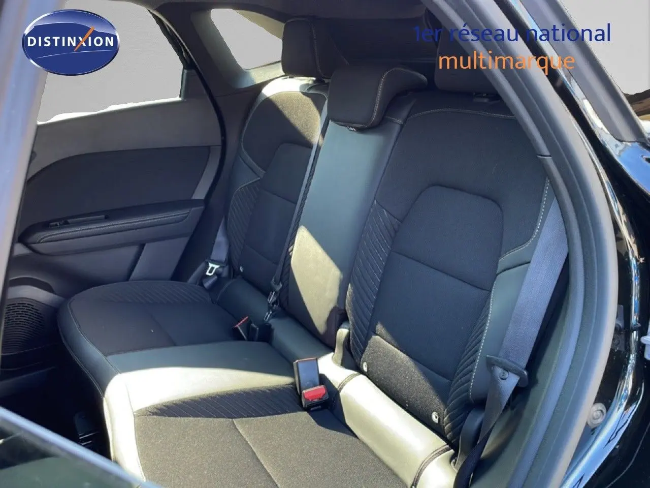 Vue intérieure montrant la banquette arrière en tissu noir avec surpiqûres, porte ouverte côté droit du Renault Symbioz noir étoile métal.