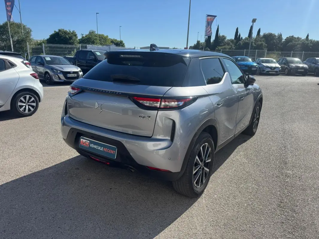 Vue 3/4 arrière droite d'une DS3 100 BVM6 Bastille gris métallisé avec jantes alliage 18 pouces sur parking extérieur.
