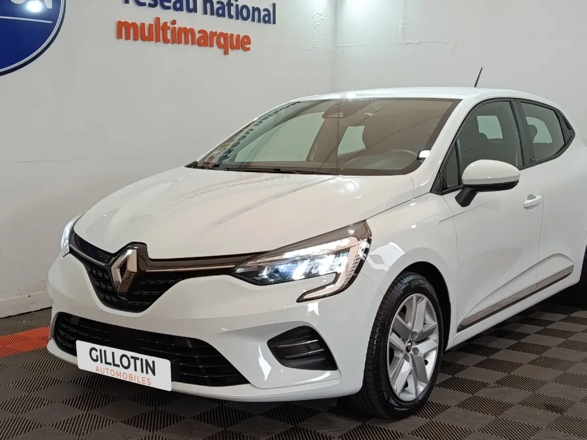 Renault Clio Business E-TECH 140 blanche vue 3/4 avant droit, phares LED allumés, calandre noire brillante.