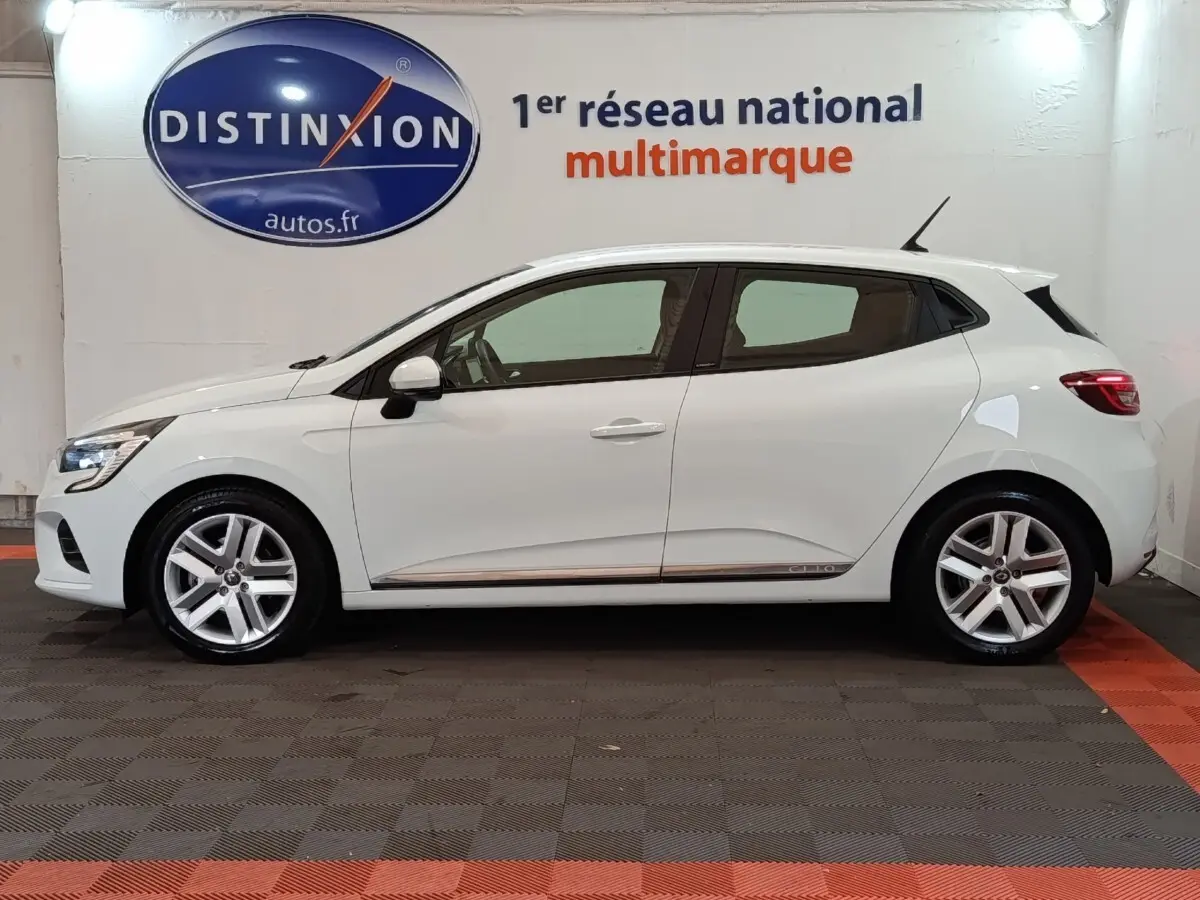 Profil droit d'une Renault Clio Business E-TECH 140 blanche, avec jantes alliage et logo Clio sur la bas de porte.