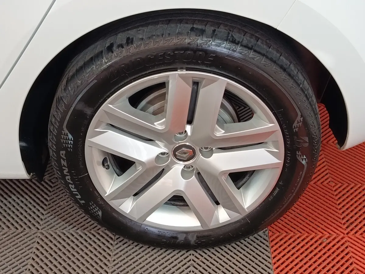 Gros plan sur la roue avant droite blanche d'une Renault Clio Business E-TECH 140 avec jante alliage et pneu Bridgestone.