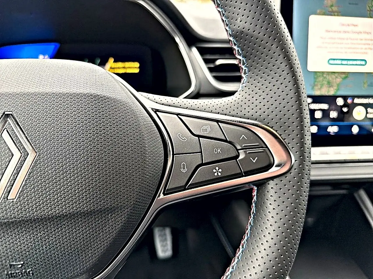 Gros plan sur le volant perforé avec commandes multifonctions et surpiqûres tricolores du Renault Symbioz 2026.