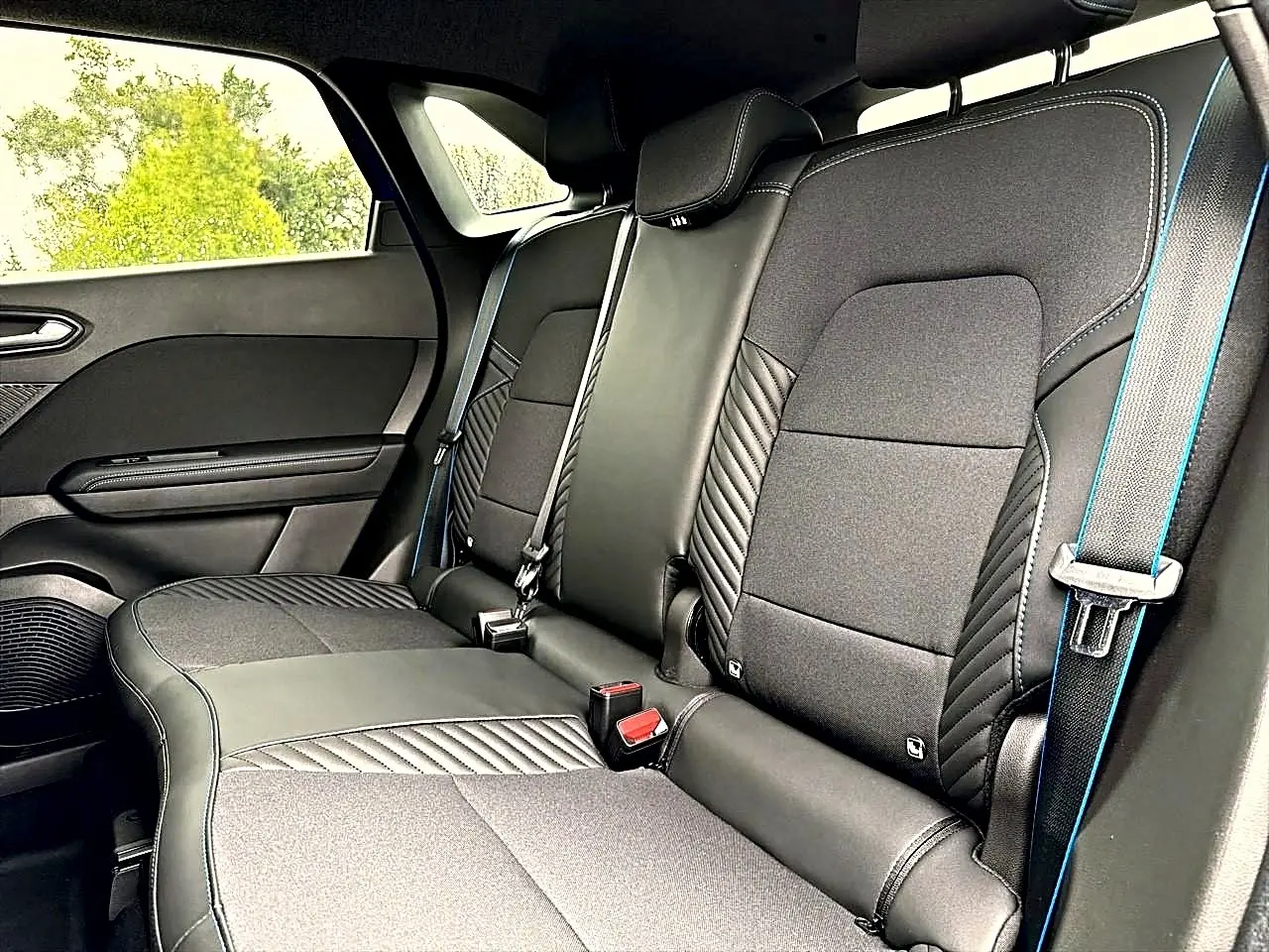 Vue intérieure côté droit de la banquette arrière noire avec surpiqûres bleues du Renault Symbioz 2026.